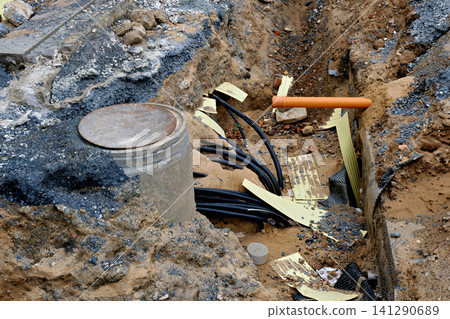 Open construction site trench with underground utility pipes and cables Open construction site trench with underground utility pipes and cables 141290689