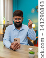 Indian man angrily removes headphones slams on table after smartphone fight big frustration reaction 141290843