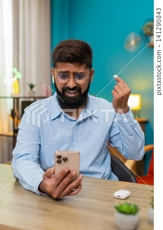 Indian man angrily removes headphones slams on table after smartphone fight big frustration reaction Indian man angrily removes headphones slams on table after smartphone fight big frustration reaction 141290843