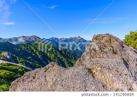 On a clear early autumn day, the Northern Alps landscape of Mt. Yarigatake and the Hotaka mountain range can be seen from the climbing route of Mt. Tsubakurodake, with the white granite rocks in the foreground in the distance. On a clear early autumn day, the Northern Alps landscape of Mt. Yarigatake and the Hotaka mountain range can be seen from the climbing route of Mt. Tsubakurodake, with the white granite rocks in the foreground in the distance. 141290884