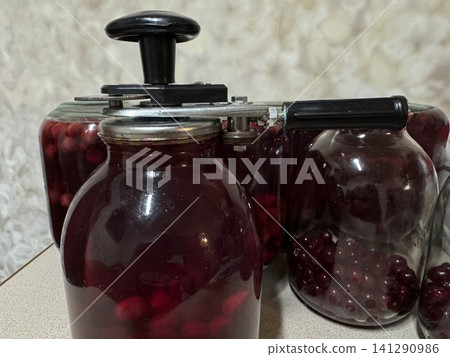 Sealing Homemade Red Berry Preserves in Glass Jars Sealing Homemade Red Berry Preserves in Glass Jars 141290986