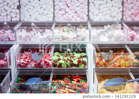 showcase of candy shop, transparent container with various sweets, marshmallow, jelly, chewy gums, rich sugar assortment showcase of candy shop, transparent container with various sweets, marshmallow, jelly, chewy gums, rich sugar assortment 141291129