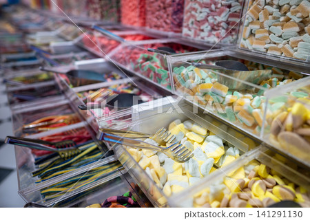 showcase of candy shop, transparent container with various sweets, marshmallow, jelly, chewy gums, rich sugar assortment showcase of candy shop, transparent container with various sweets, marshmallow, jelly, chewy gums, rich sugar assortment 141291130