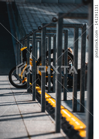 small kid bicycle parked and attached by chain tie, urban city view small kid bicycle parked and attached by chain tie, urban city view 141291131