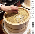 Opening the lid of the steamer basket 141291223