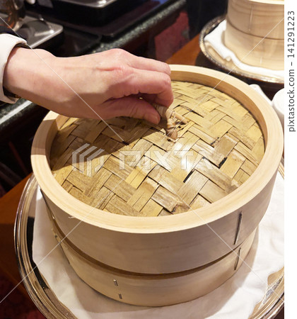 Opening the lid of the steamer basket 141291223