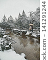 The backs of two people walking leisurely through the quiet, snowy Kenrokuen Garden, sharing an umbrella. 141291244