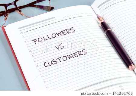 Handwritten comparison between social media followers and business customers showcased on an open journal with elegant stationery items for a professional planning session Handwritten comparison between social media followers and business customers showcased on an open journal with elegant stationery items for a professional planning session 141291763