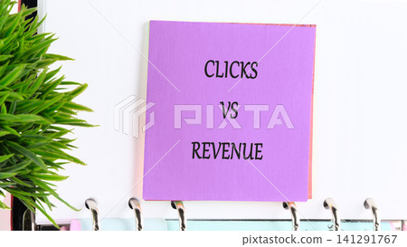 Purple sticky note with written text exploring the relationship between digital traffic and financial earnings displayed on a notebook near a lush plant in a quiet workspace Purple sticky note with written text exploring the relationship between digital traffic and financial earnings displayed on a notebook near a lush plant in a quiet workspace 141291767