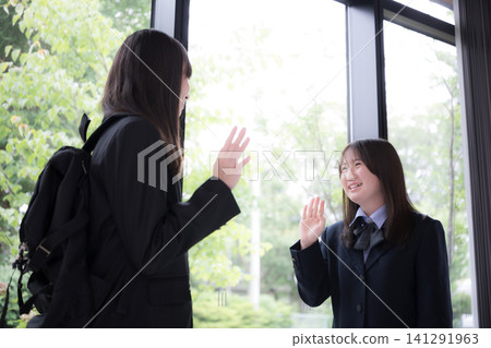 畫面展現了兩名日本國中高中女生在學校裡互相微笑問候、進出學校的場景,以及校園生活的景象。 畫面展現了兩名日本國中高中女生在學校裡互相微笑問候、進出學校的場景,以及校園生活的景象。 141291963