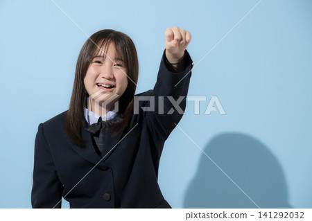 Middle and high school girls in their uniforms stand against a light blue background, smiling and looking at the camera, striking a triumphant pose to convey energy, encouragement, and their determination to pass their exams. Middle and high school girls in their uniforms stand against a light blue background, smiling and looking at the camera, striking a triumphant pose to convey energy, encouragement, and their determination to pass their exams. 141292032