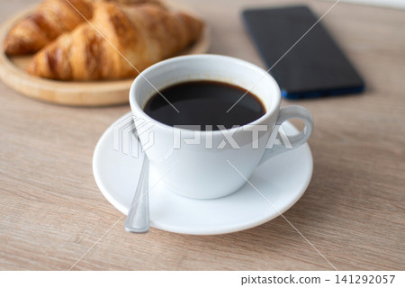 Buttered whole wheat toast with black coffee and smartphone Buttered whole wheat toast with black coffee and smartphone 141292057