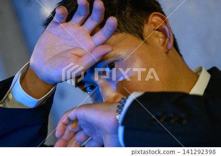 Close-up of a man hiding his face Close-up of a man hiding his face 141292398