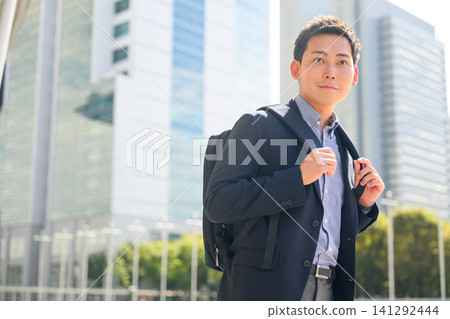 Businessman carrying a backpack Businessman carrying a backpack 141292444