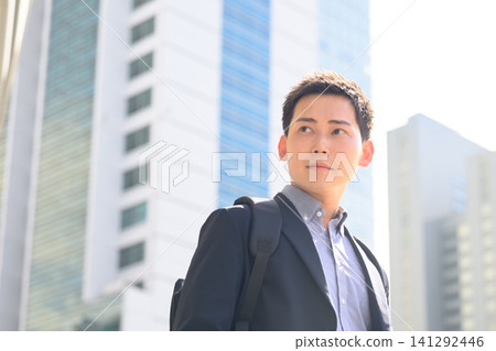A businessman walks through the city streets. A businessman walks through the city streets. 141292446