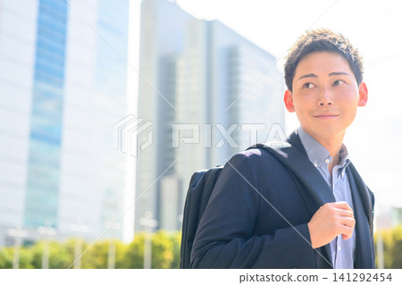 一名男子站在摩天大樓前。 141292454