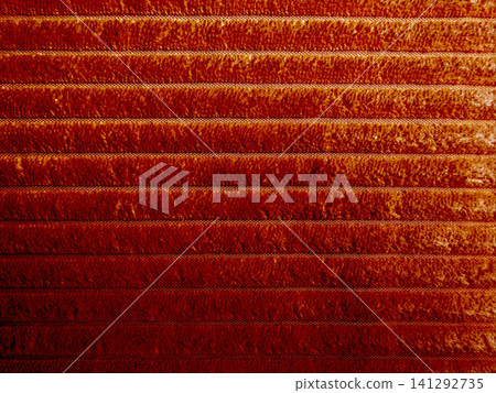 burnt orange ribbed corduroy fabric texture background with warm cinematic shadows 141292735