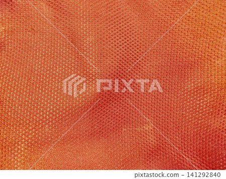 orange textured silk fabric close up reveals intricate geometric weave patterns shimmering under warm studio lighting orange textured silk fabric close up reveals intricate geometric weave patterns shimmering under warm studio lighting 141292840
