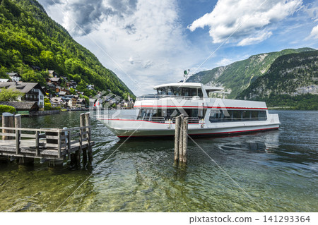 Boat on Lake Hallstatt with mountain landscape in a picturesque village, illustrating European small town charm and waterfront. 141293364