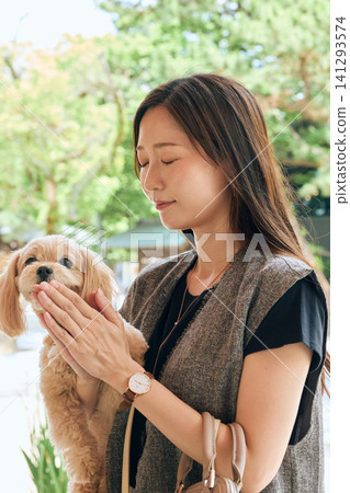 A young woman smiling and hugging her dog outdoors. 141293574