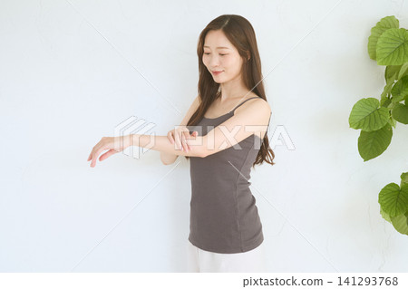 年輕女性的護膚流程:觸摸並檢查手臂上的皮膚。 年輕女性的護膚流程:觸摸並檢查手臂上的皮膚。 141293768