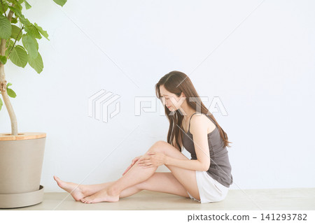 A young woman doing skincare on her legs at home A young woman doing skincare on her legs at home 141293782