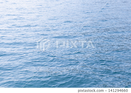 Light blue lake water surface with ripple pattern Light blue lake water surface with ripple pattern 141294660