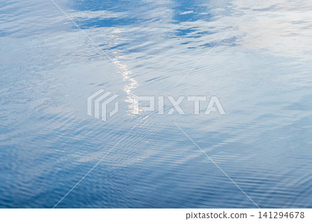 Shiny blue still water surface with smooth ripples Shiny blue still water surface with smooth ripples 141294678