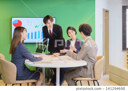 Four young Japanese men and women having a meeting in the office. Four young Japanese men and women having a meeting in the office. 141294698