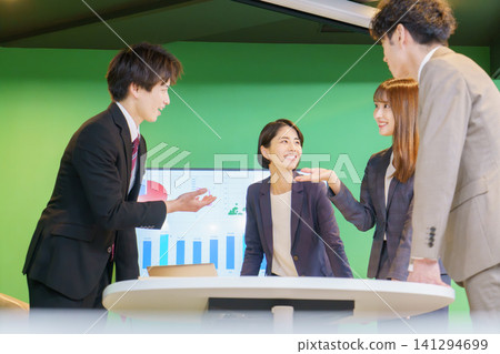 Four young Japanese men and women having a meeting in the office. Four young Japanese men and women having a meeting in the office. 141294699