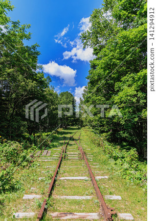 夏天的陽光照耀著上石幌町幌子車站遺址上美麗的鐵路道口。 夏天的陽光照耀著上石幌町幌子車站遺址上美麗的鐵路道口。 141294912