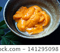 A close-up of fresh sea urchin from Hokkaido served in a small bowl. 141295098