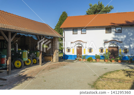 South Moravian farmstead featuring folk architecture barn and old tractors South Moravian farmstead featuring folk architecture barn and old tractors 141295360