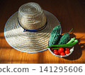 Fresh summer vegetables harvested from the home garden and a straw hat 141295606