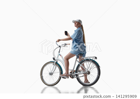 Woman sitting on bicycle and holding smartphone on white background. Woman sitting on bicycle and holding smartphone on white background. 141295909