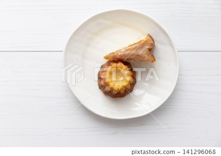 白色盤子上擺放著自製可露麗和蛋糕。 白色盤子上擺放著自製可露麗和蛋糕。 141296068