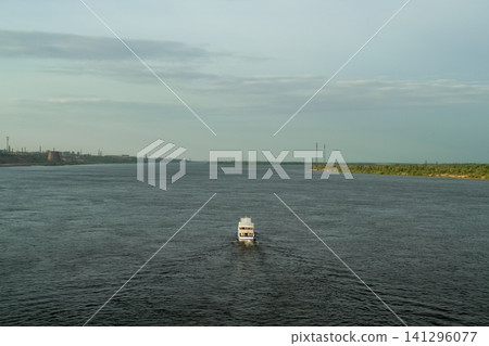 Single boat moving across vast water surface toward distant horizon. Concept of solitude, freedom and travel with minimal composition. Single boat moving across vast water surface toward distant horizon. Concept of solitude, freedom and travel with minimal composition. 141296077