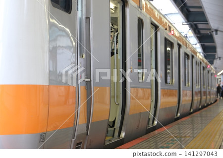 中央線 E233 系列通勤列車的入口/出口和不鏽鋼車身停靠在東京月台上。 中央線 E233 系列通勤列車的入口/出口和不鏽鋼車身停靠在東京月台上。 141297043