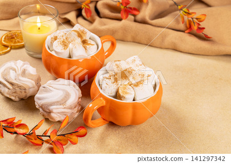 Hot chocolate with marshmallows in pumpkin mugs Hot chocolate with marshmallows in pumpkin mugs 141297342