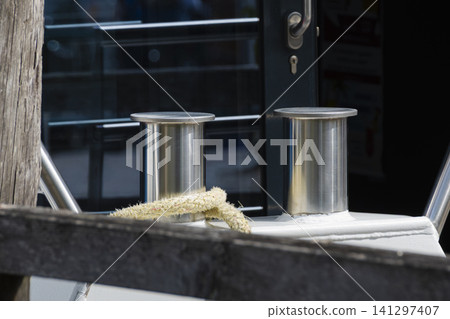 Stainless steel mooring bollards with rope on a boat deck, creating an authentic atmosphere suitable for nautical lifestyle. Stainless steel mooring bollards with rope on a boat deck, creating an authentic atmosphere suitable for nautical lifestyle. 141297407