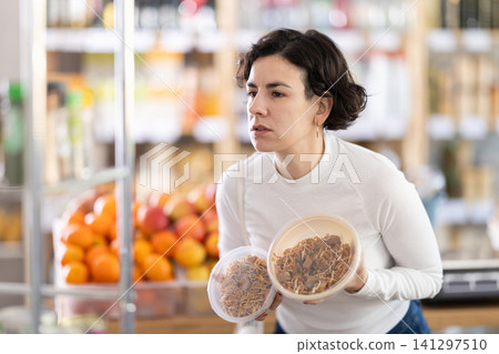 Adult woman choosing yakisoba in grocery store Adult woman choosing yakisoba in grocery store 141297510