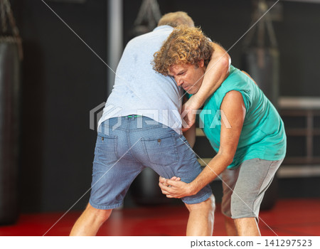 Male pupil clash with training manager during self-defense lesson, repulse charge, intensity of practice Male pupil clash with training manager during self-defense lesson, repulse charge, intensity of practice 141297523