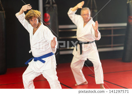 Karate student performing kata with instructor Karate student performing kata with instructor 141297571