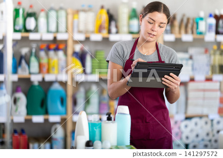 Young woman seller conducting inventory with tablet Young woman seller conducting inventory with tablet 141297572