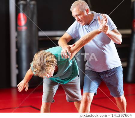 Male pupil clash with training manager during self-defense lesson, repulse charge, intensity of practice 141297604