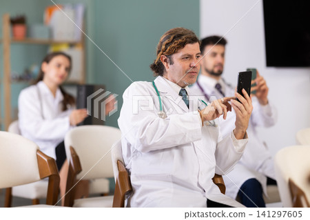 Medical students take pictures of information during meeting or lecture 141297605