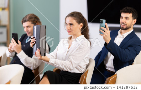 Group of businessmen using mobile phones to scan QR-code during interactive lesson Group of businessmen using mobile phones to scan QR-code during interactive lesson 141297612