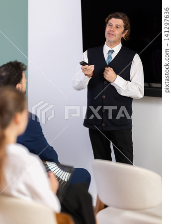 Male business trainer explaining topic to professionals using digital board Male business trainer explaining topic to professionals using digital board 141297636