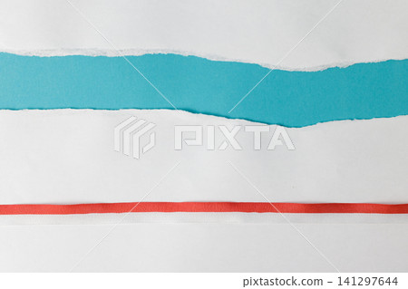 Top-down view of torn white paper showing a blue background and decorated with a red and white ribbon at the bottom, offering copy space. High Quality Photo Top-down view of torn white paper showing a blue background and decorated with a red and white ribbon at the bottom, offering copy space. High Quality Photo 141297644