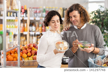 Couple chooses a cooked salad in a package Couple chooses a cooked salad in a package 141297748